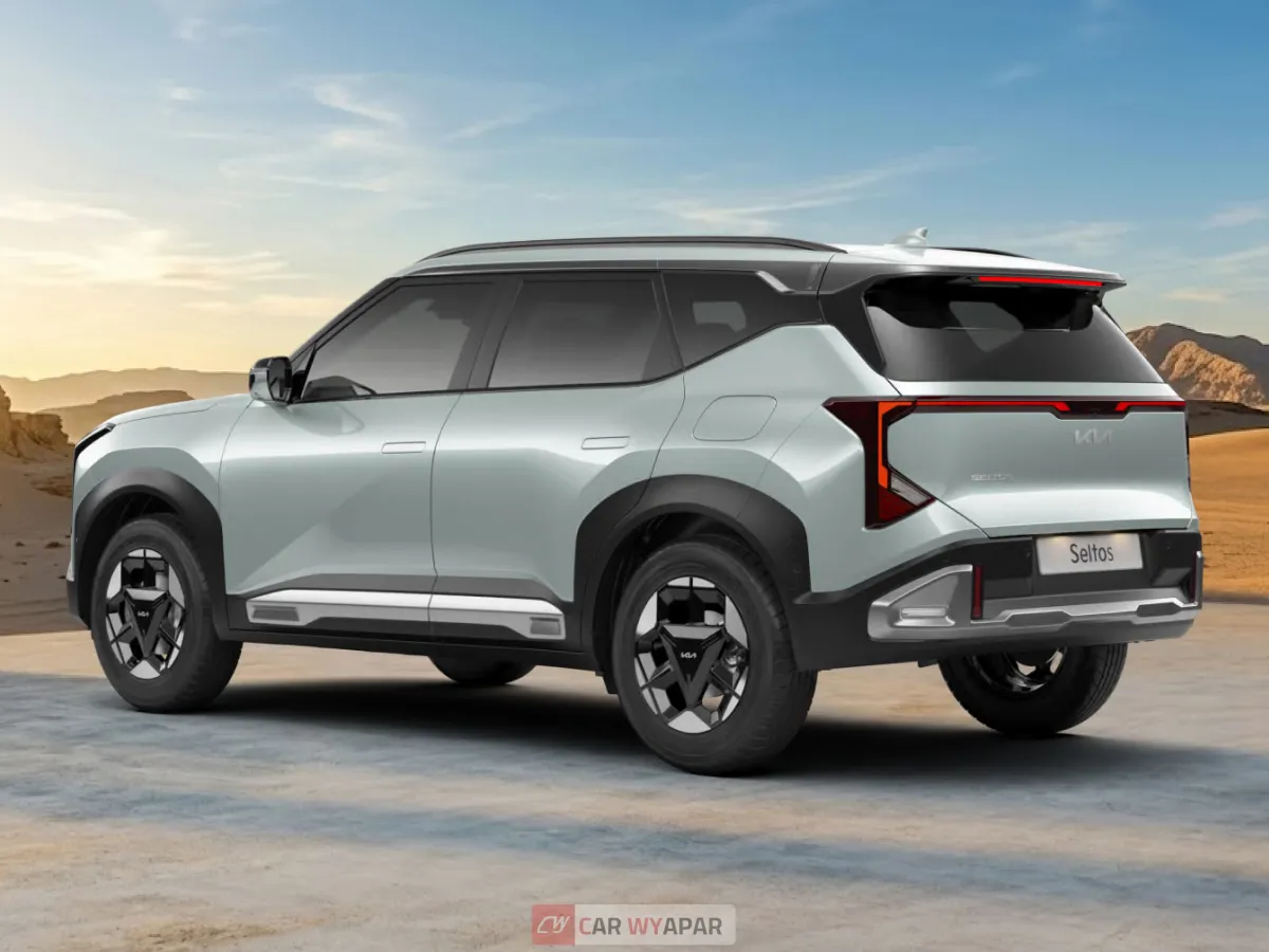 Rear three-quarter view of a light silver/mint Kia Seltos HTX in a desert setting, highlighting the dual-tone alloy wheels and rear spoiler.